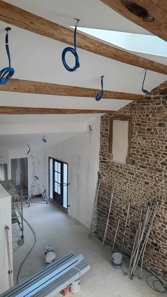 Enduits et préparation autour de poutres et d’un mur en pierre