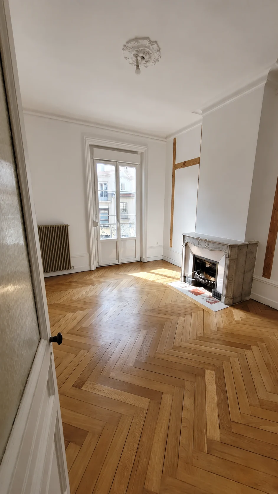 Pièce avec cheminée pendant la rénovation, avec bois encore apparents sur le mur